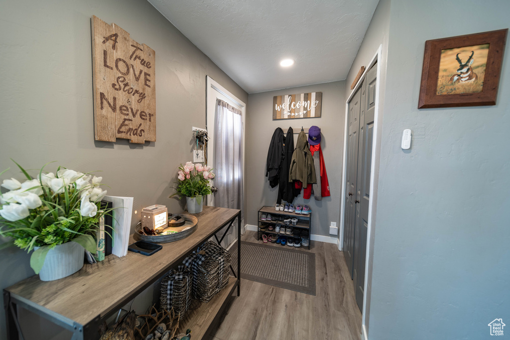 Mudroom featuring baseboards, a chandelier, and wood finished floors