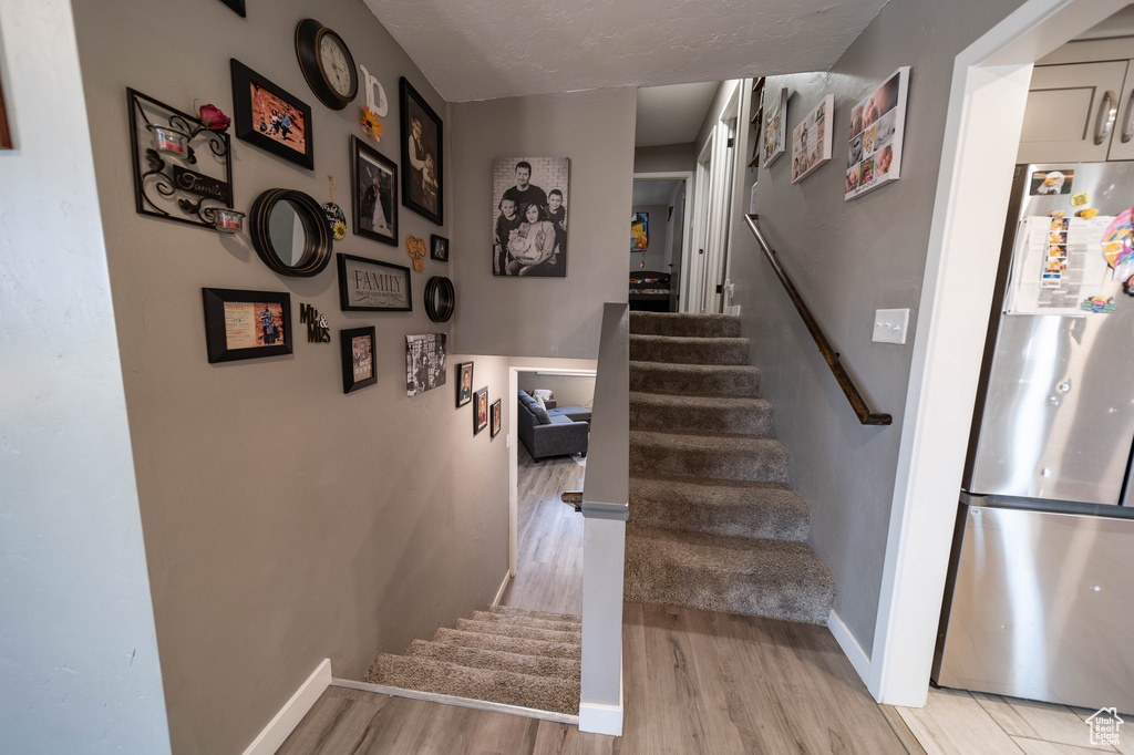Stairway with baseboards and wood finished floors