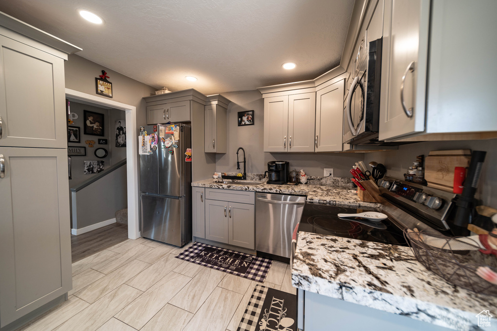 Kitchen featuring gray cabinets, appliances with stainless steel finishes, a sink, and recessed lighting