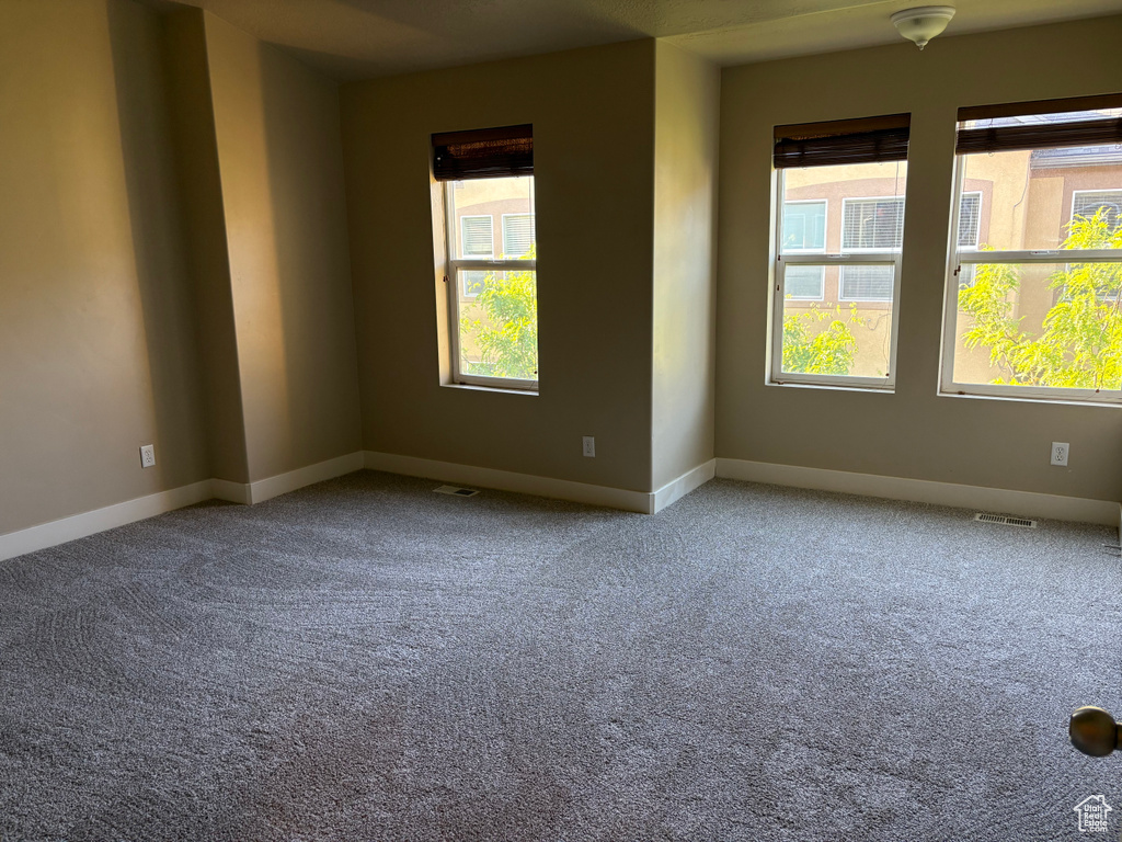 Carpeted empty room featuring baseboards