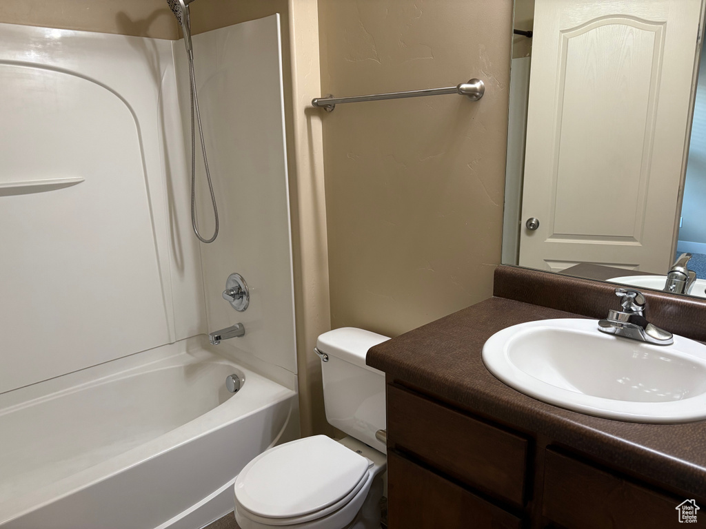 Full bathroom featuring toilet, vanity, and tub / shower combination