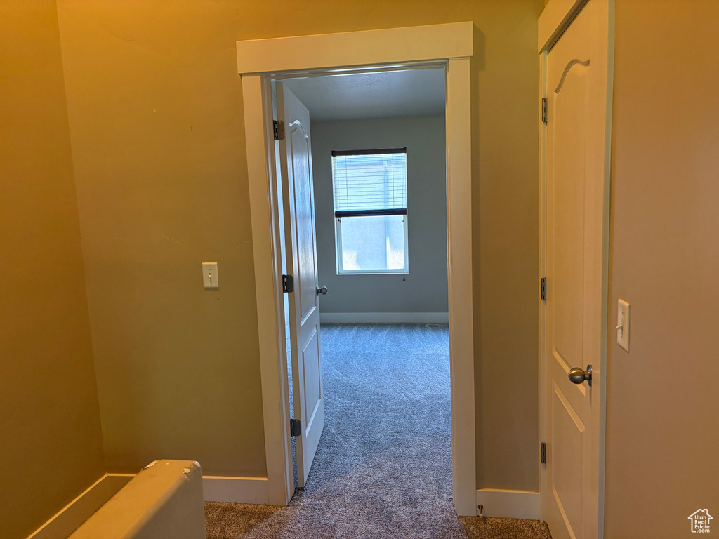 Hallway with carpet floors and baseboards