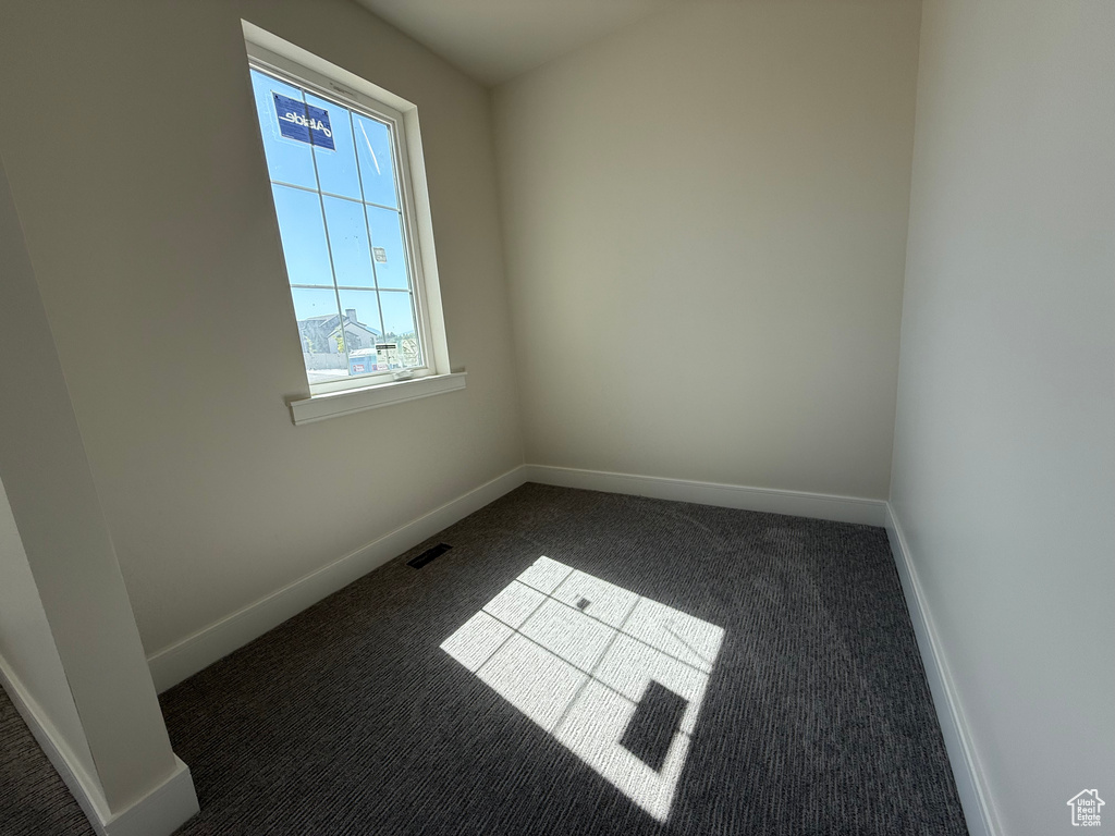 Carpeted empty room featuring baseboards