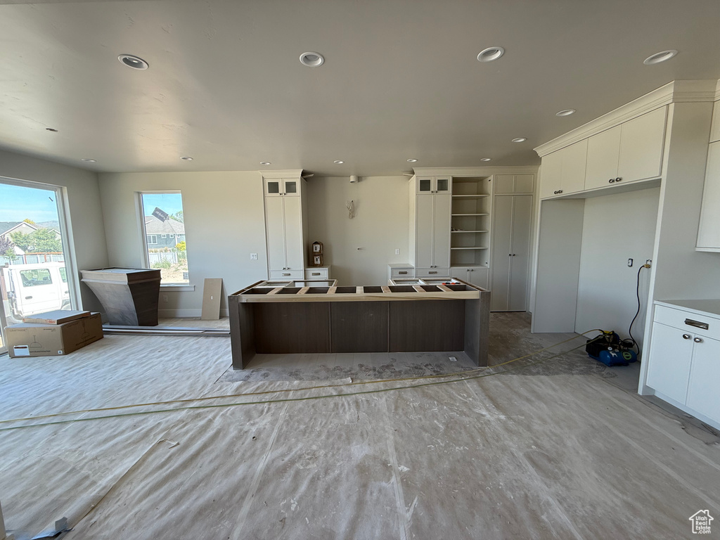 Kitchen featuring white cabinets, a kitchen island, and recessed lighting