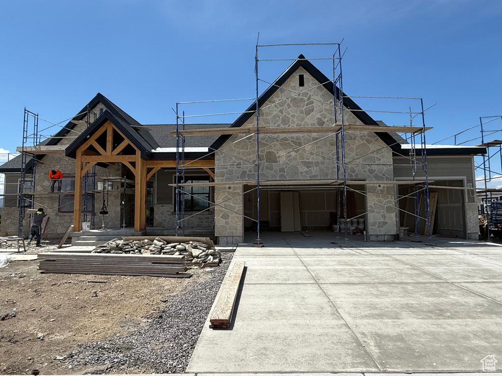 View of front of house featuring stone siding and driveway