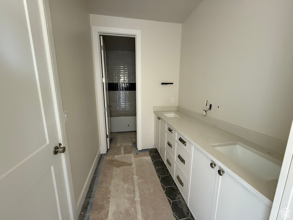 Bathroom featuring double vanity and baseboards