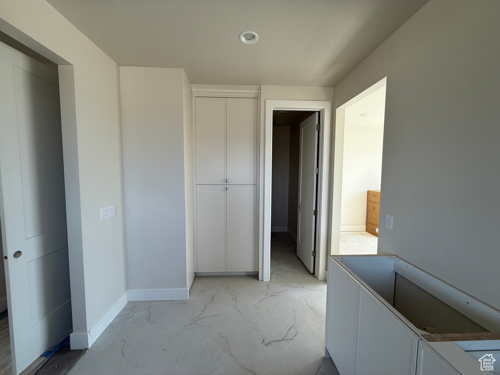 Unfurnished bedroom with a closet, light marble finish flooring, and recessed lighting
