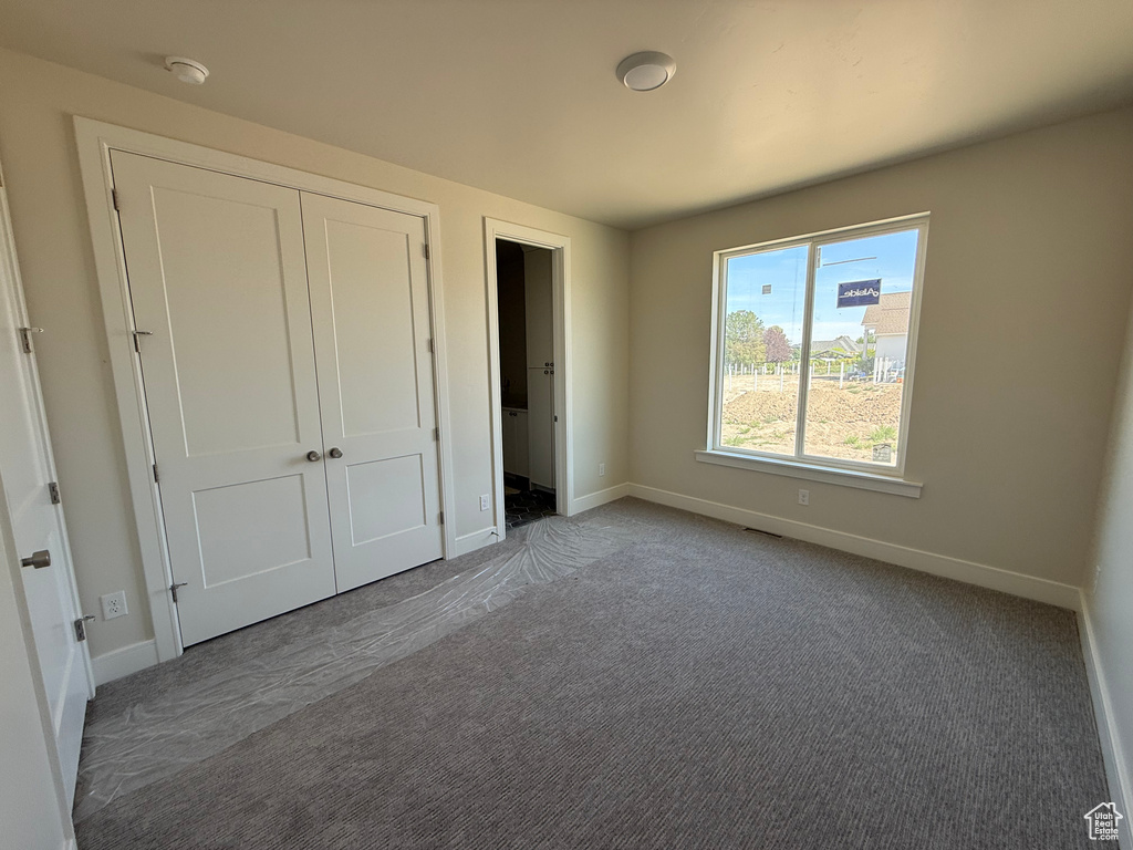 Unfurnished bedroom with a closet and carpet flooring