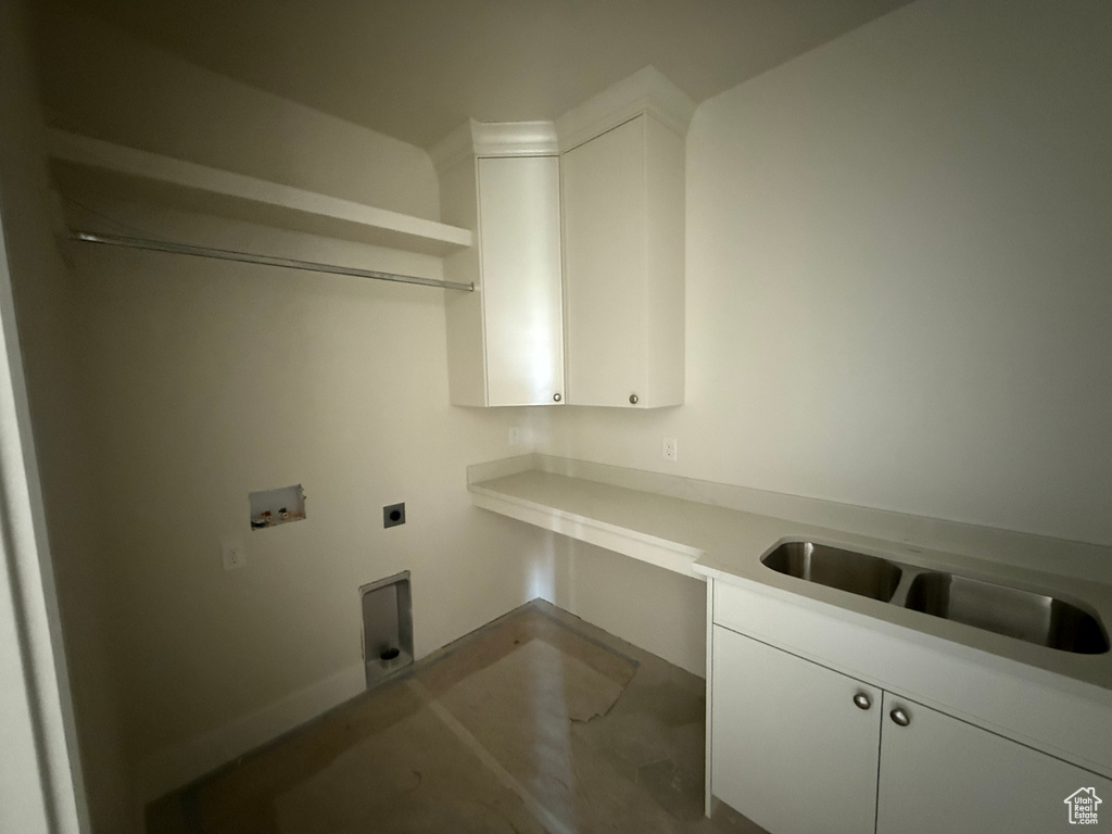 Washroom featuring hookup for an electric dryer, washer hookup, and cabinet space