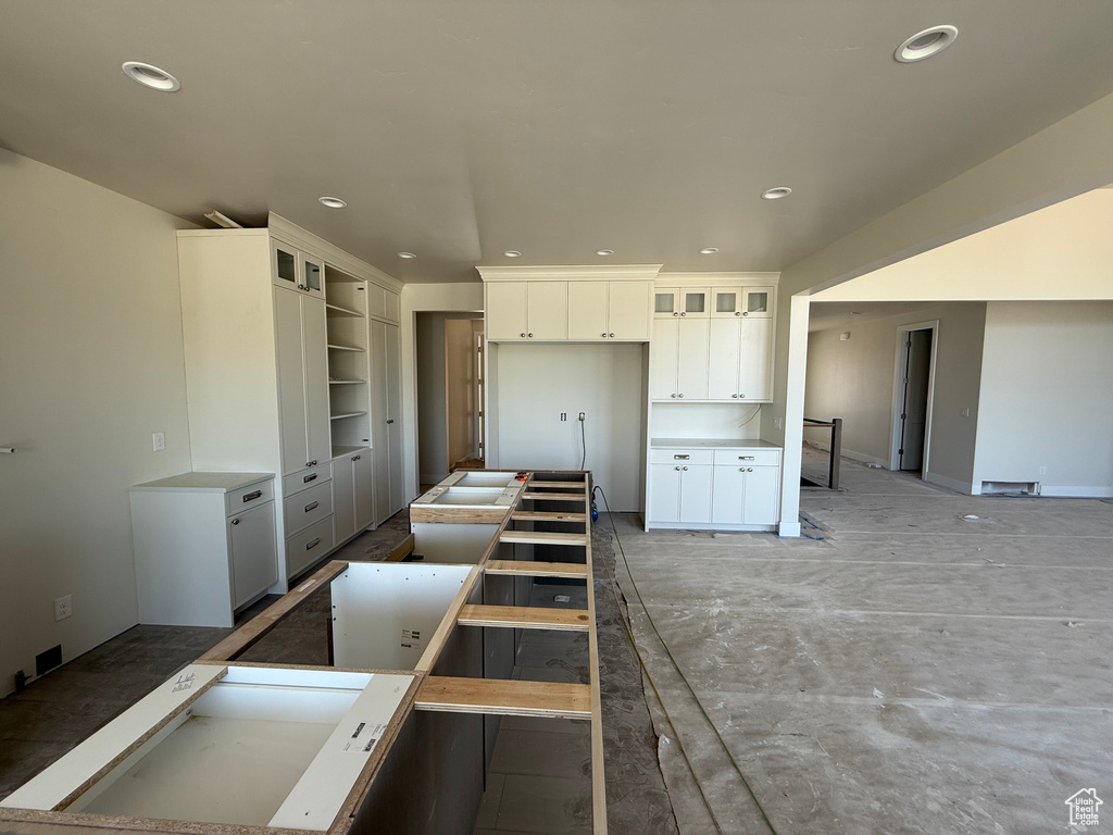 Kitchen featuring white cabinets, recessed lighting, and glass insert cabinets