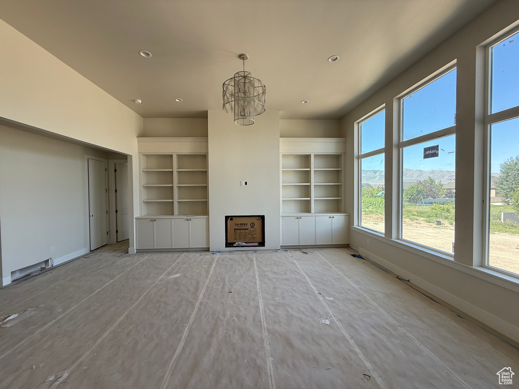 Unfurnished living room with a chandelier and recessed lighting