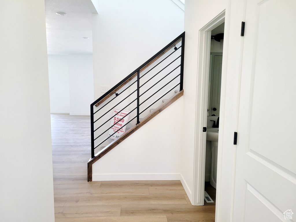 Staircase with baseboards and wood finished floors