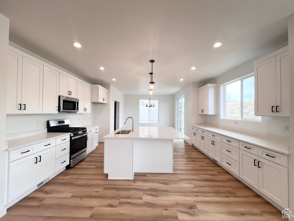 Kitchen featuring a sink, recessed lighting, white cabinetry, and stainless steel appliances