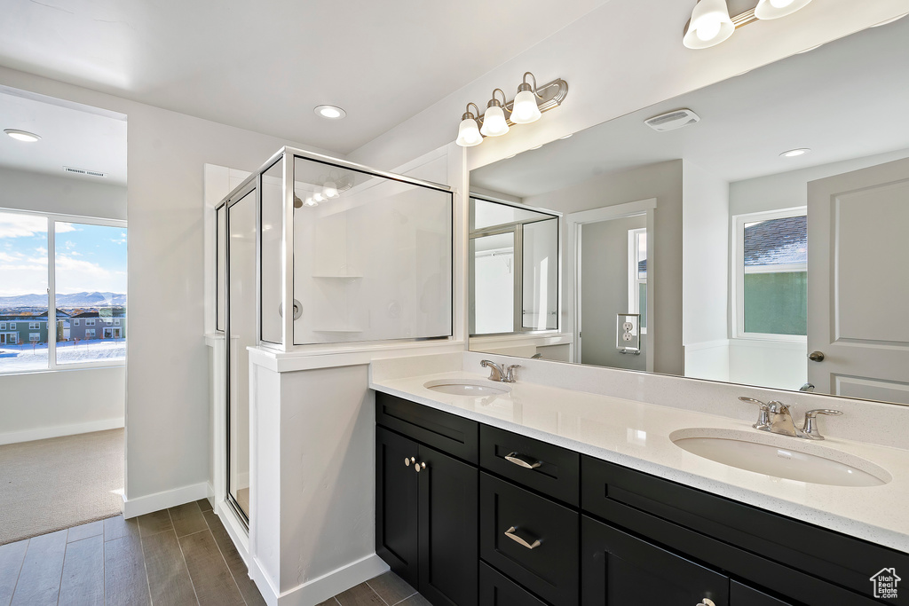 Full bath featuring a sink, visible vents, a stall shower, and wood finished floors