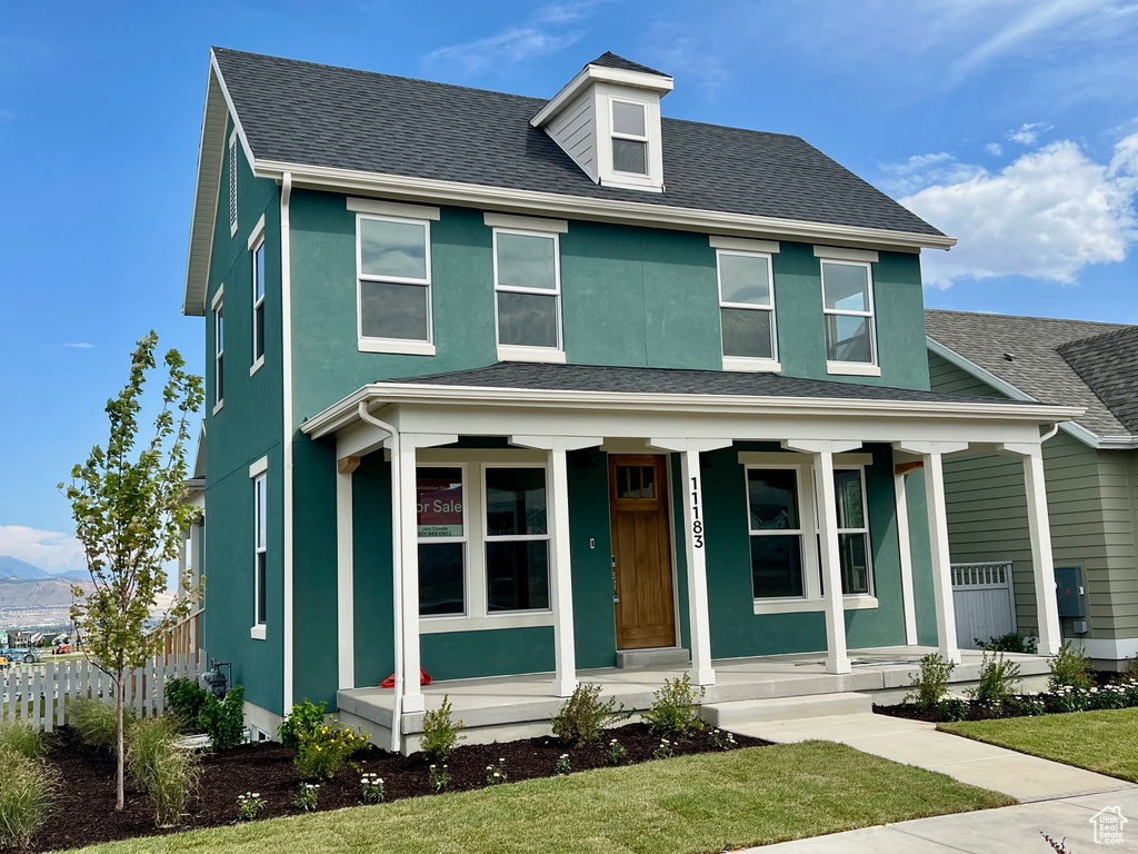 View of front of home featuring covered porch, roof with shingles, stucco siding, and a mountain view