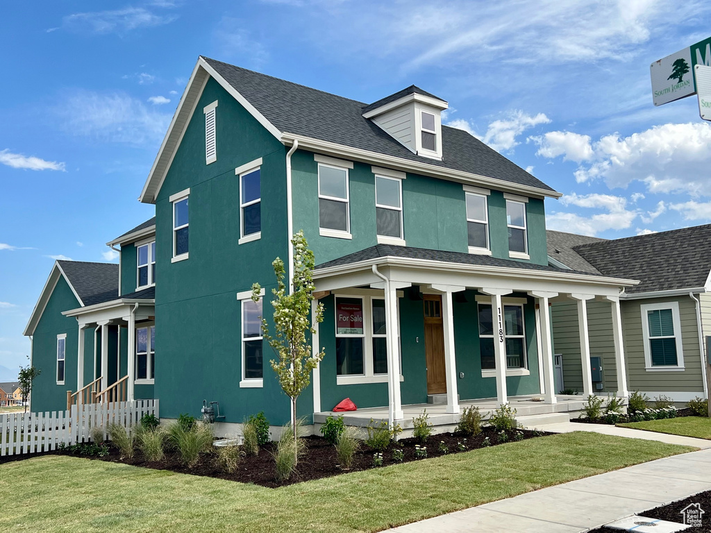 View of front of home featuring covered porch, stucco siding, and a shingled roof