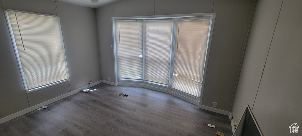 Unfurnished room featuring wood finished floors, baseboards, and visible vents