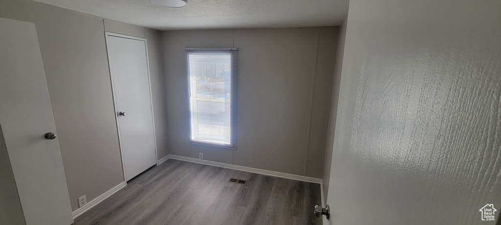 Spare room with visible vents, baseboards, and wood finished floors