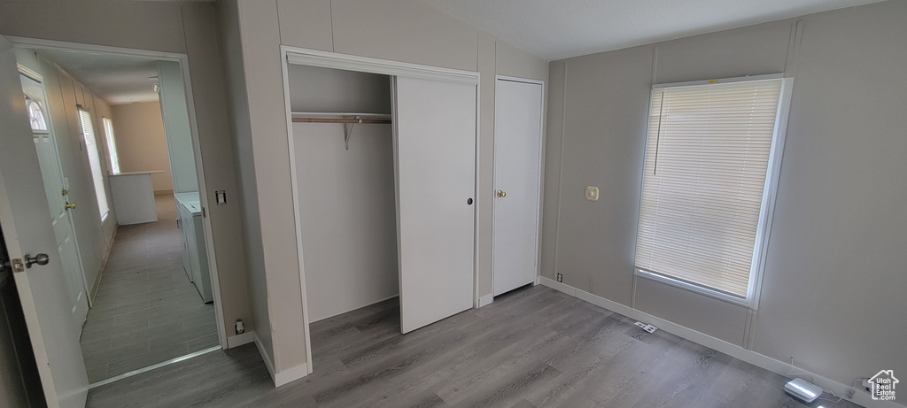 Unfurnished bedroom featuring baseboards, two closets, and light wood-style floors