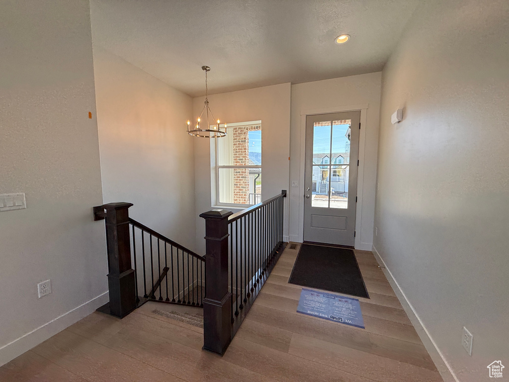 Entryway with wood finished floors, baseboards, a chandelier, and recessed lighting