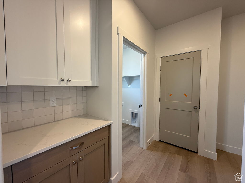 Corridor with light wood-style floors and baseboards