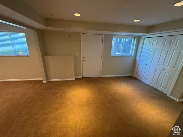 Unfurnished bedroom with light carpet, multiple windows, recessed lighting, and baseboards