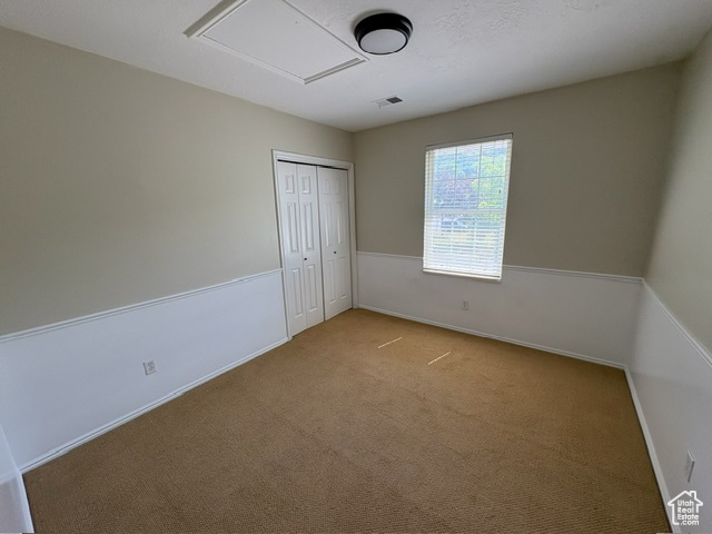 Unfurnished bedroom featuring carpet flooring, a closet, and baseboards