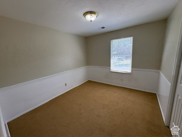 Carpeted spare room with baseboards