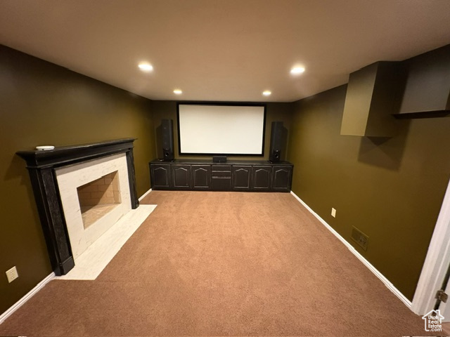 Cinema room featuring light carpet, recessed lighting, a fireplace with flush hearth, and baseboards