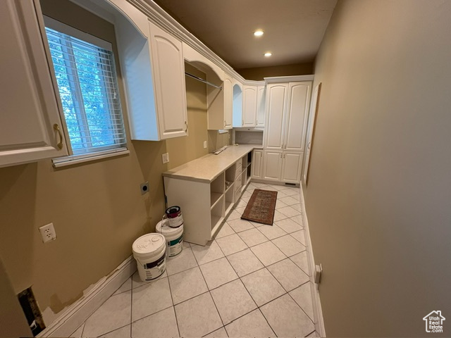 Washroom featuring light tile patterned floors, electric dryer hookup, cabinet space, recessed lighting, and baseboards