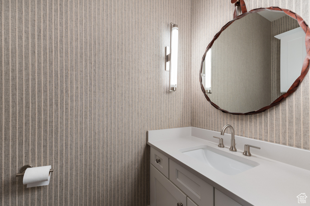 Bathroom with wallpapered walls and vanity