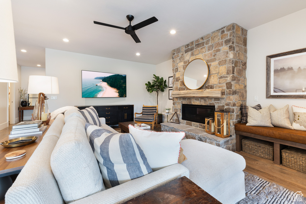 Living room featuring a fireplace, wood finished floors, ceiling fan, and recessed lighting