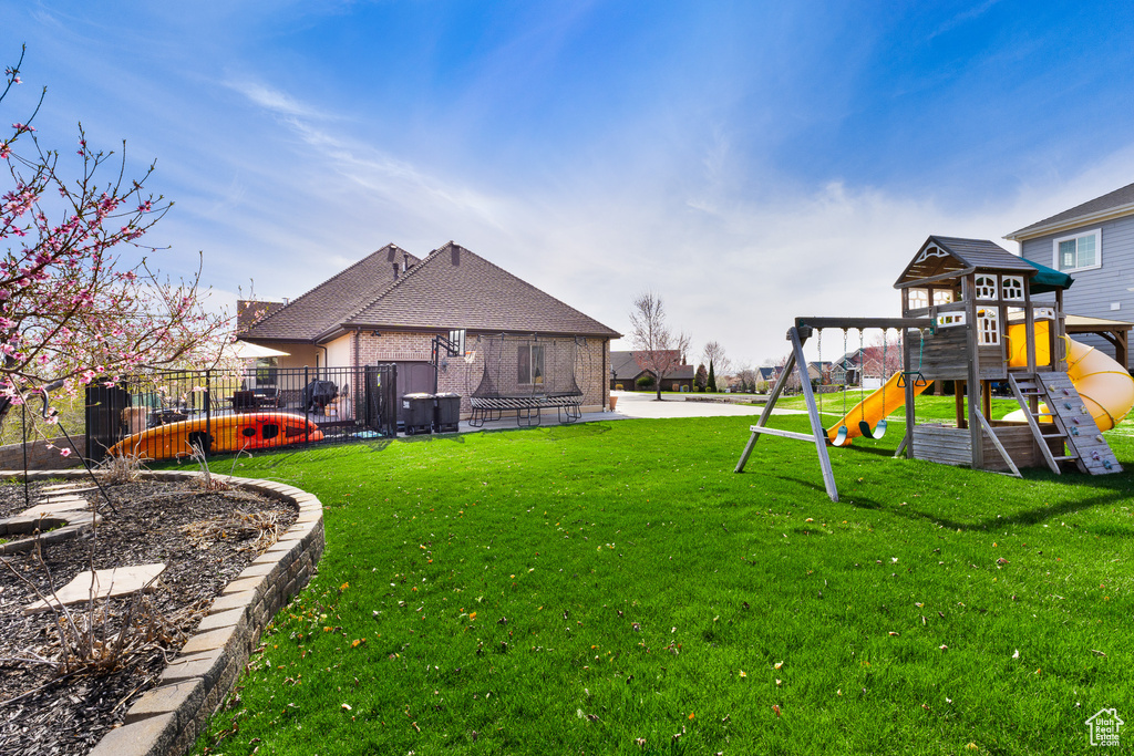 View of yard featuring fence and a playground