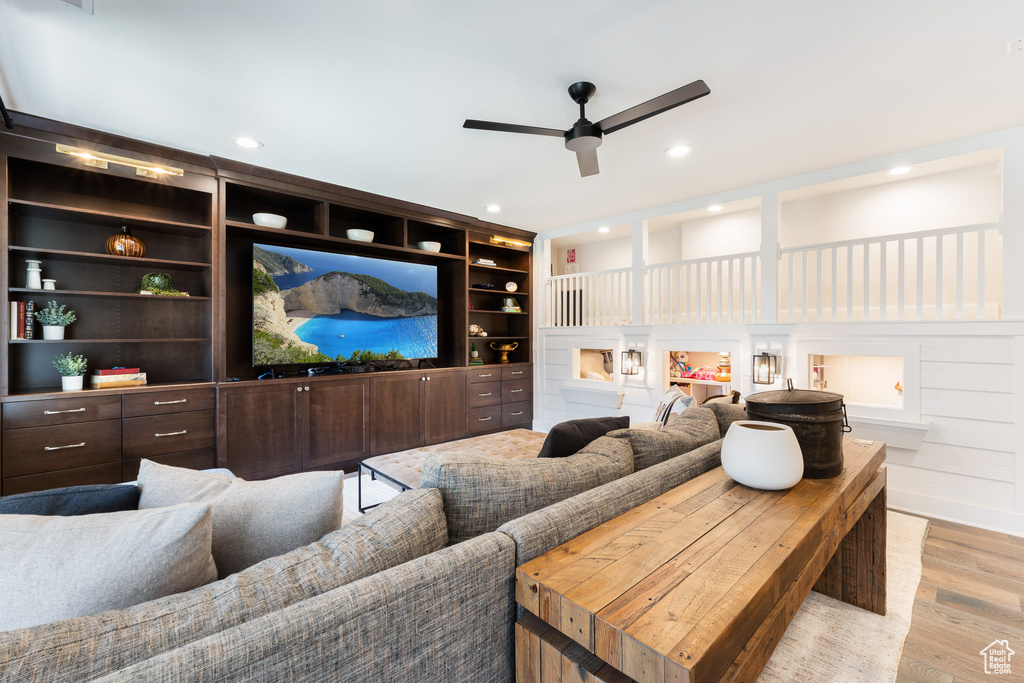 Home theater with a ceiling fan, wood finished floors, and recessed lighting