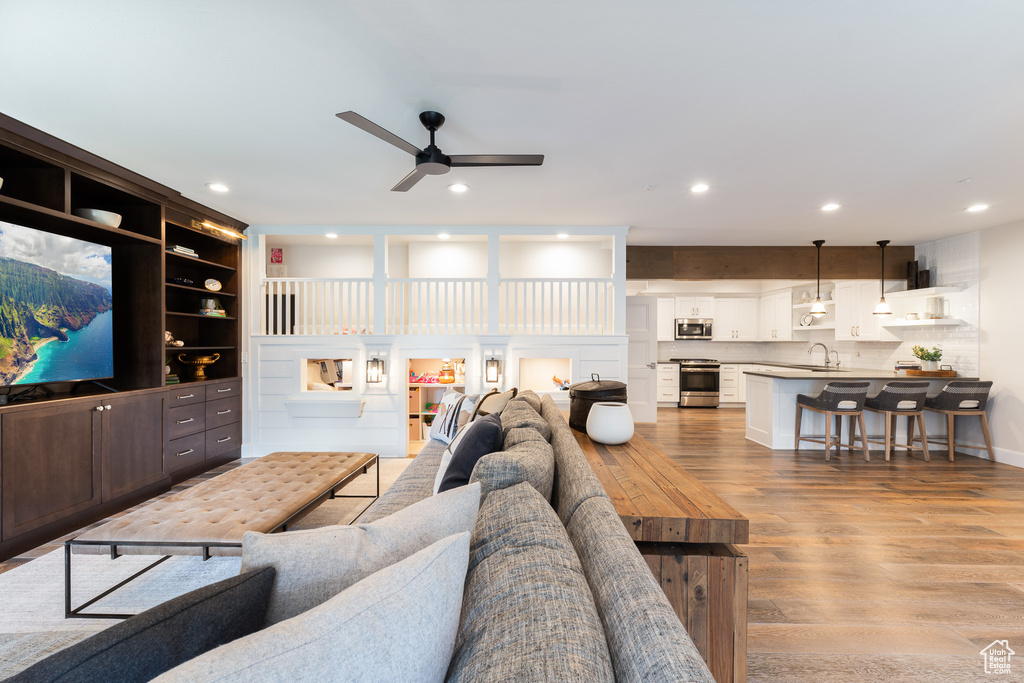 Living area with recessed lighting, light wood-style flooring, and a ceiling fan