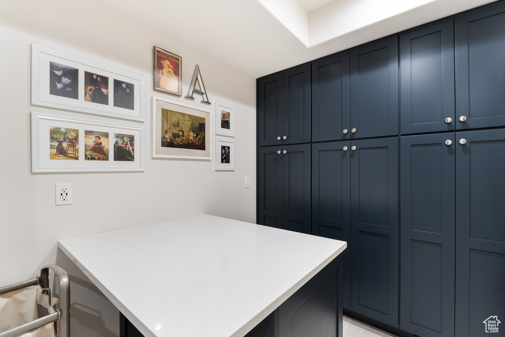 Kitchen with a peninsula, light countertops, and blue cabinetry