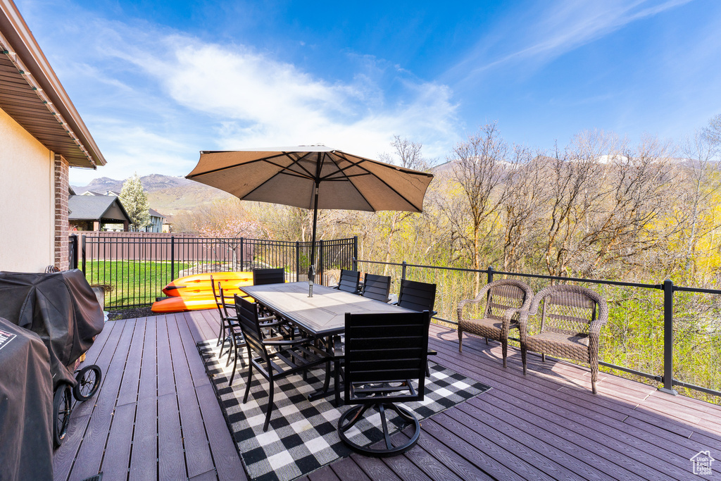Deck with a mountain view and outdoor dining space