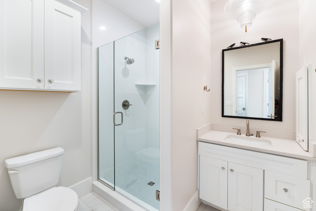 Bathroom featuring a shower stall, baseboards, toilet, and vanity