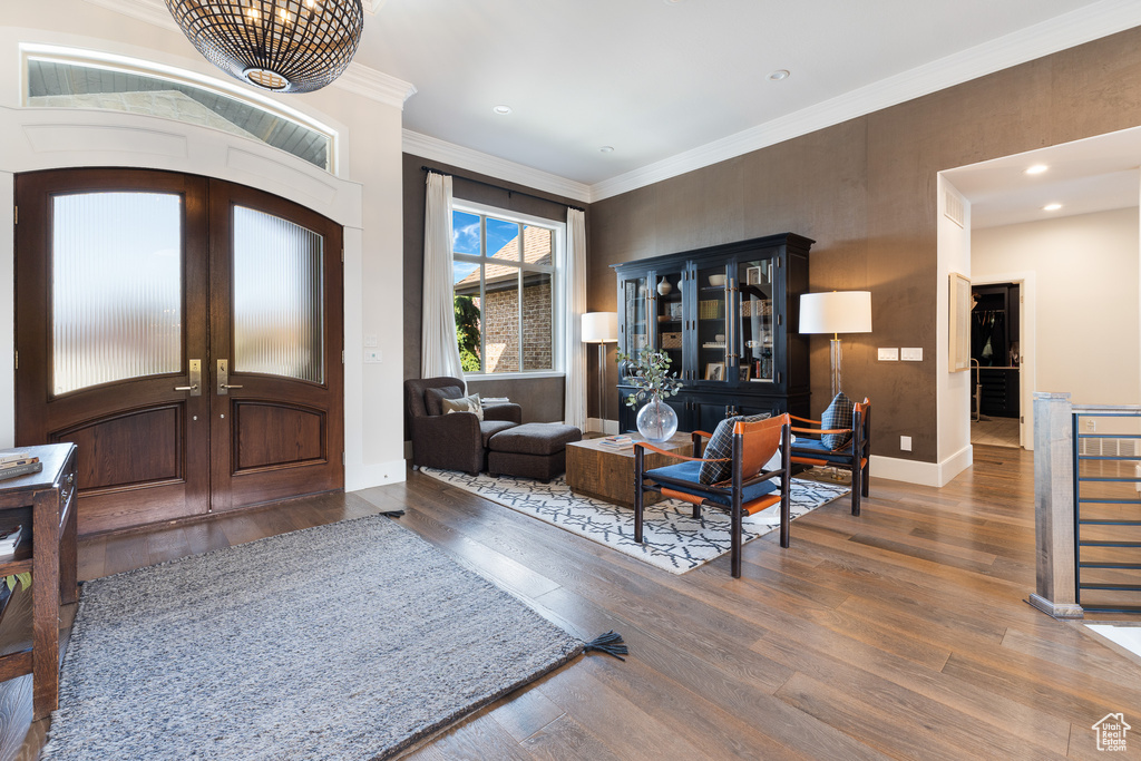 Foyer with wood finished floors, french doors, baseboards, ornamental molding, and recessed lighting