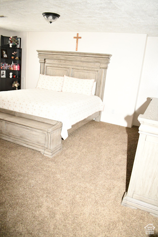 Bedroom featuring a textured ceiling, visible vents, and carpet floors