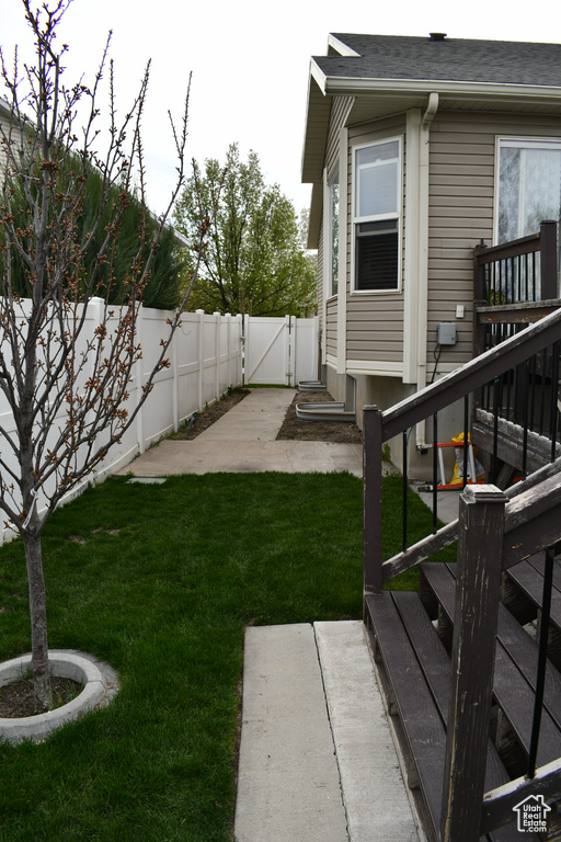 View of yard with a fenced backyard, stairs, a patio area, and a gate