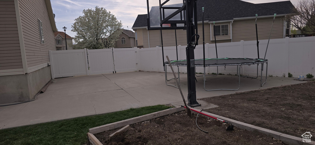 View of patio featuring a fenced backyard and a trampoline