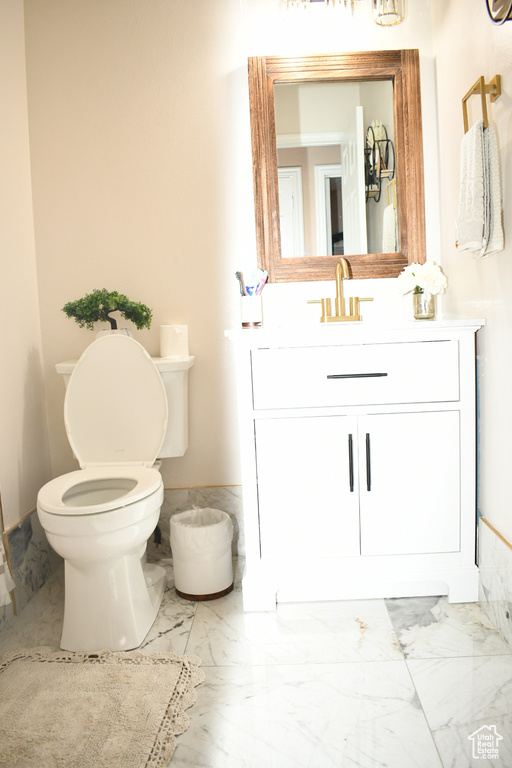 Bathroom featuring vanity, marble finish floor, and toilet