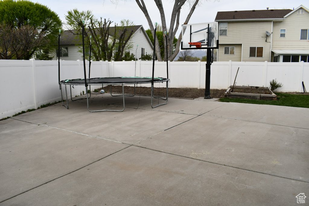 View of patio featuring a fenced backyard and a trampoline