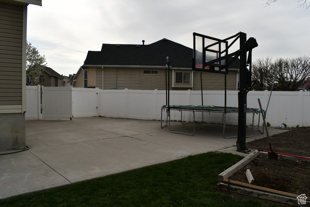 View of patio featuring a trampoline and a fenced backyard