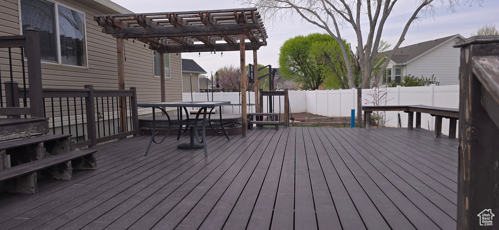 Deck featuring outdoor dining space, a fenced backyard, and a pergola