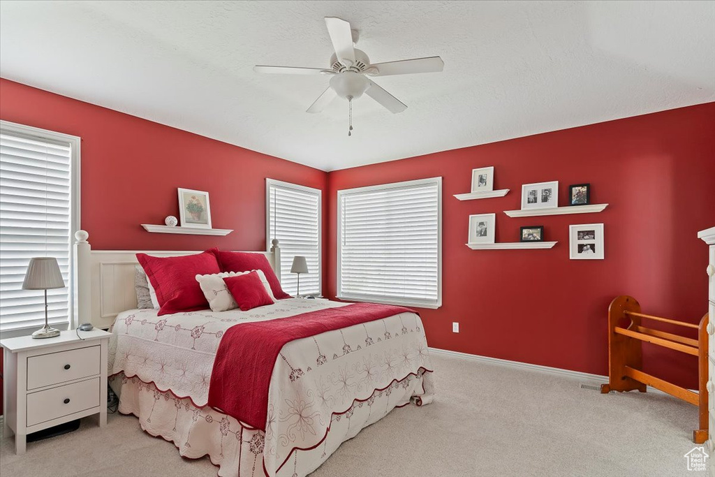 Carpeted bedroom featuring a ceiling fan
