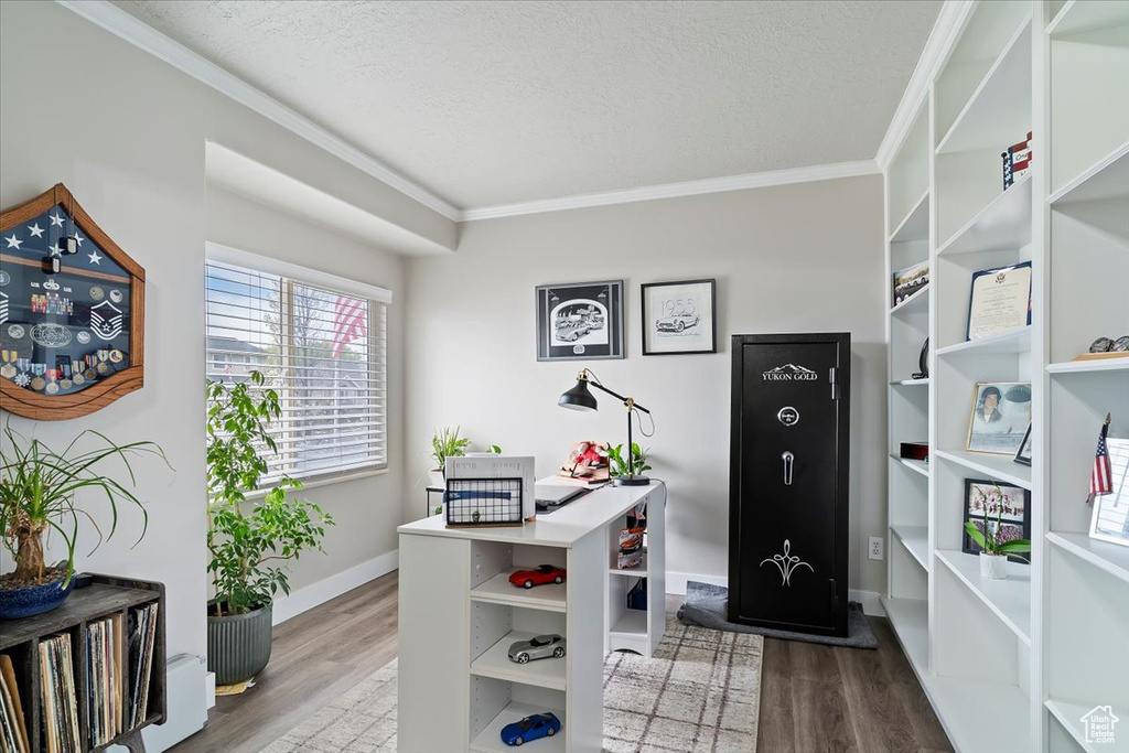 Home office with crown molding, wood finished floors, baseboards, and a textured ceiling