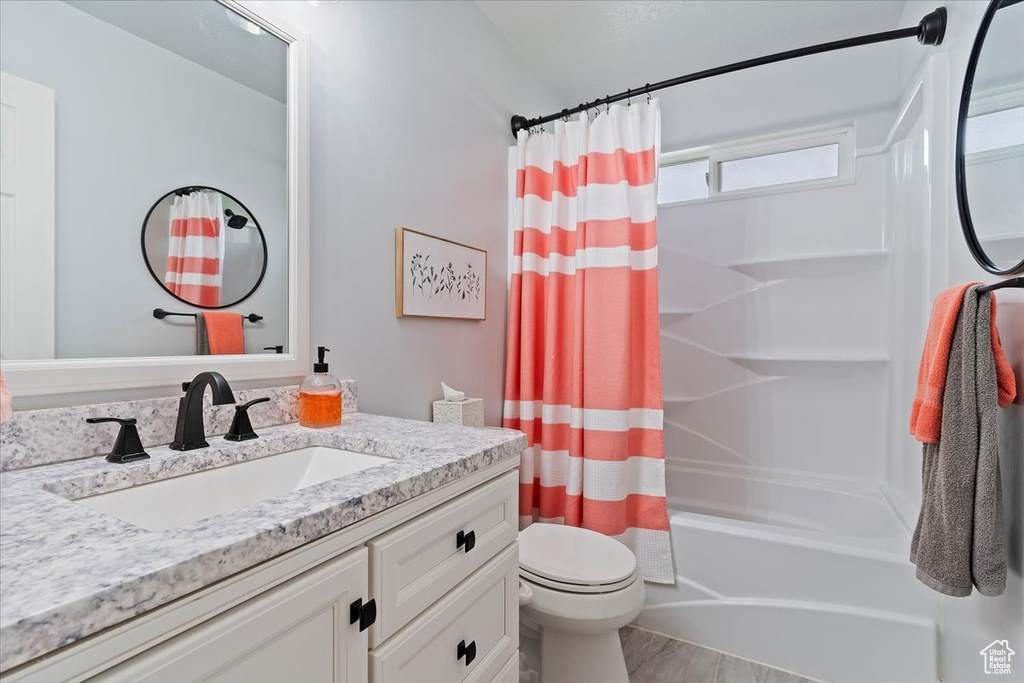 Bathroom with shower / bath combo, toilet, vanity, and wood finished floors