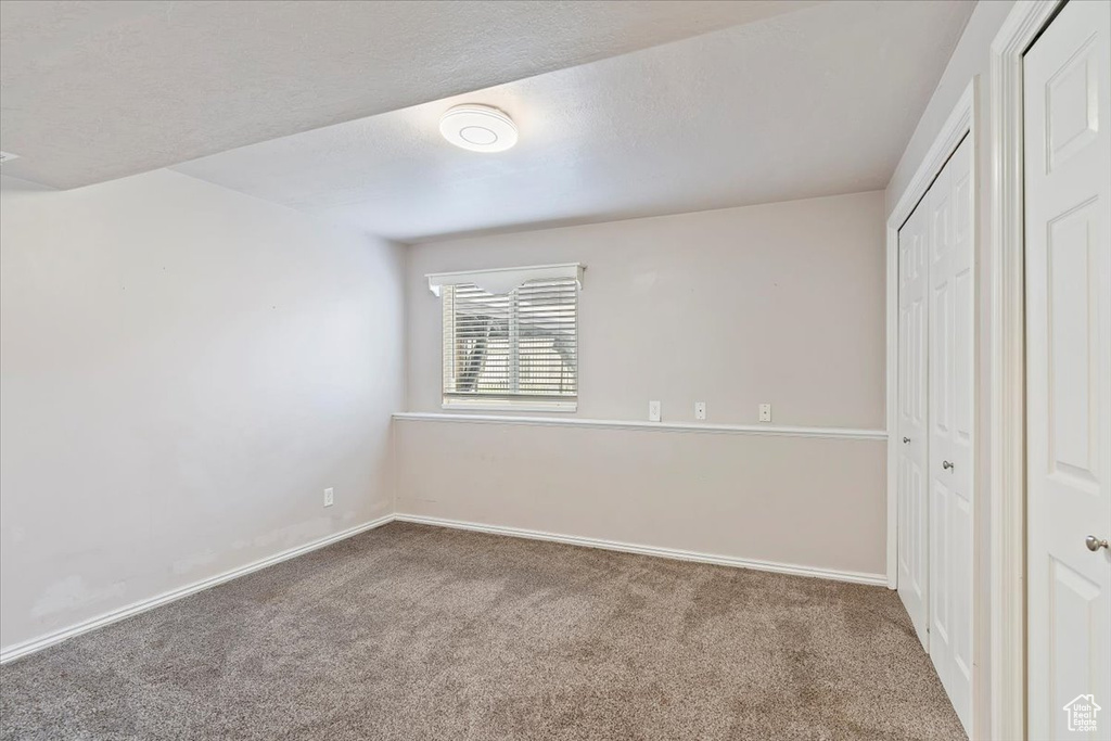 Unfurnished bedroom featuring a closet, baseboards, and carpet floors